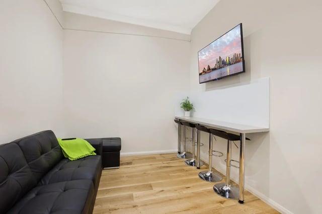Black couch bar stools and TV living room at Link2 Central in Sydney Student Accommodation