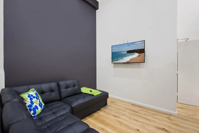 Black sectional sofa wall mounted TV living room at Link2 Central in Sydney Student Accommodation