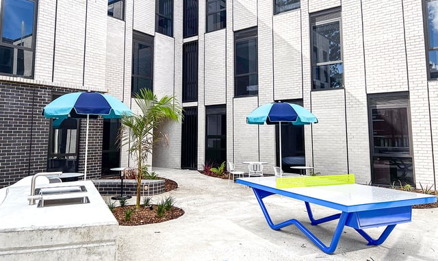 Outdoor kitchen sink ping pong table umbrellas exterior at The Switch Kensington in Sydney Student Accommodation