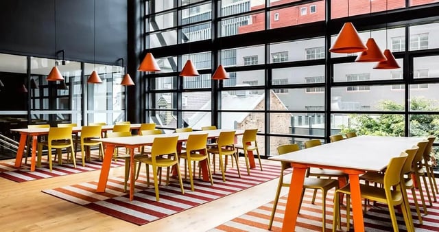 Orange tables yellow chairs striped rugs communal area at Iglu Broadway in Sydney Student Accommodation
