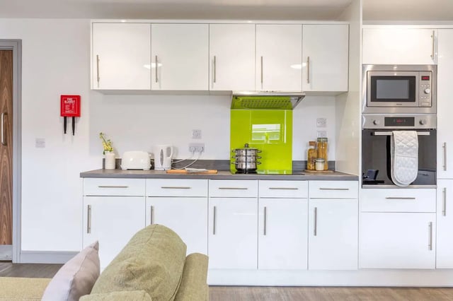 White cabinets microwave oven pots pans kitchen at The Foundry in Leeds Student Accommodation