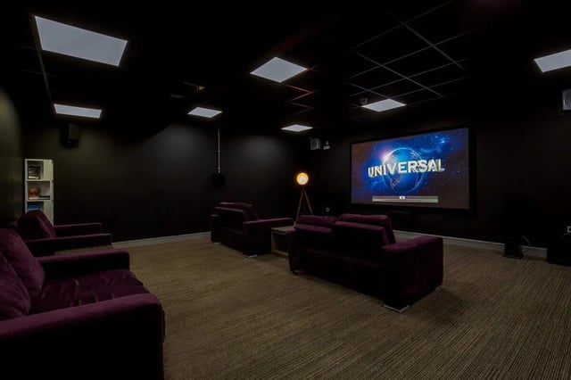 Dark cinema room with plush seating and projection screen cinema room at The Foundry in Leeds Student Accommodation