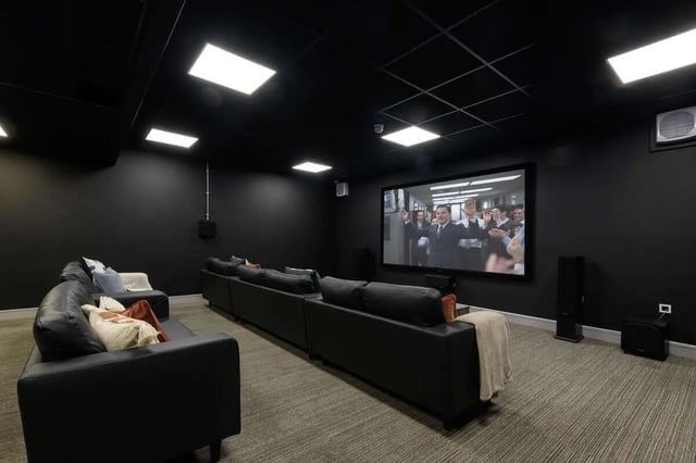 Black sofas large screen speakers movie room at The Foundry in Leeds Student Accommodation
