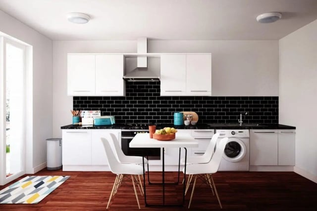 White cabinets black tiled splashback dining table and chairs kitchen at Moss Court in Manchester Student Accommodation