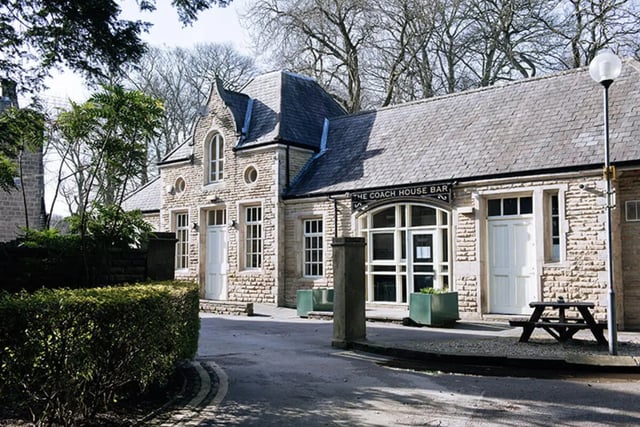 Stone building with bar entrance and picnic table Exterior at Oxley Residence in Leeds Student Accommodation