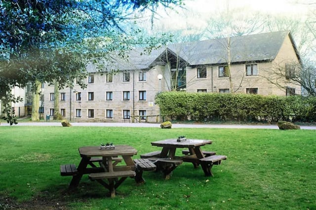 Wooden picnic tables on lawn exterior. at Oxley Residence in Leeds Student Accommodation