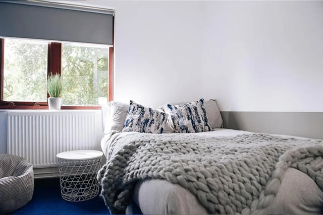 Bed with cushions radiator white side table bedroom at Oxley Residence in Leeds Student Accommodation