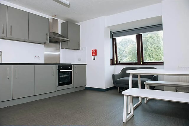 Grey kitchen cabinets oven sofa table benches communal kitchen at Oxley Residence in Leeds Student Accommodation