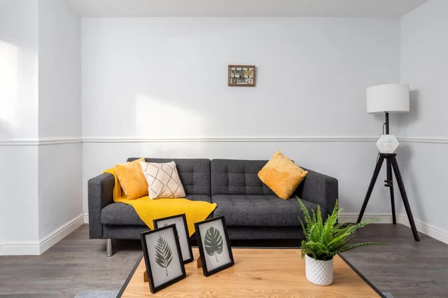 Sofa with yellow cushions and blanket living room at Thornville Court Leeds in Leeds Student Accommodation