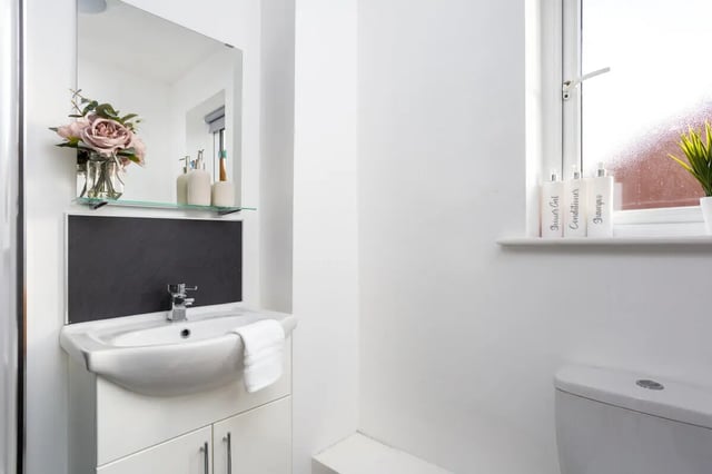 Sink mirror flowers bottles and toilet bathroom at Thornville Court Leeds in Leeds Student Accommodation