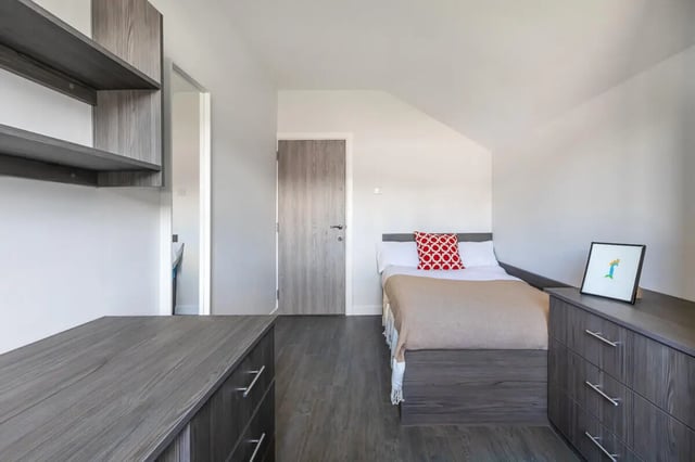 Bed dresser shelves and framed art Bedroom at Hyde Park in Leeds Student Accommodation