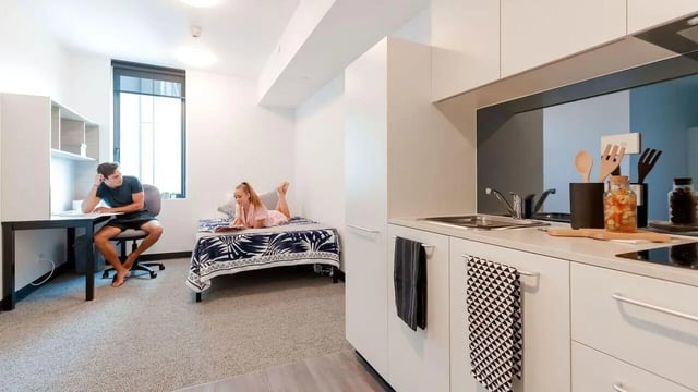 Student room with desk bed and kitchen study area at UniLodge Park Central in Brisbane Student Accommodation