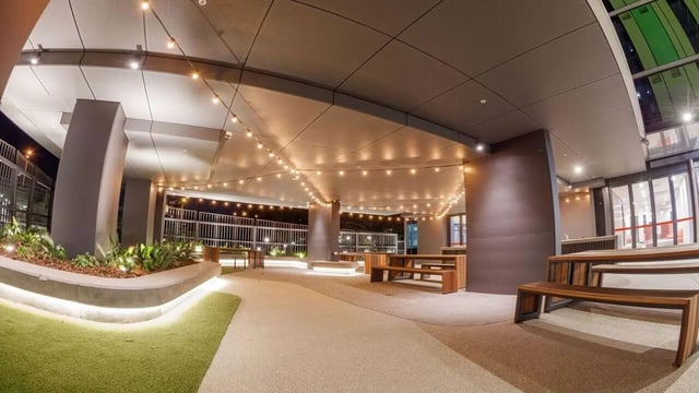 Wooden benches and tables under string lights outdoor area at UniLodge Park Central in Brisbane Student Accommodation