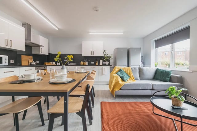 Dining table couch refrigerators kitchen living room at Madison Gardens in Nottingham Student Accommodation