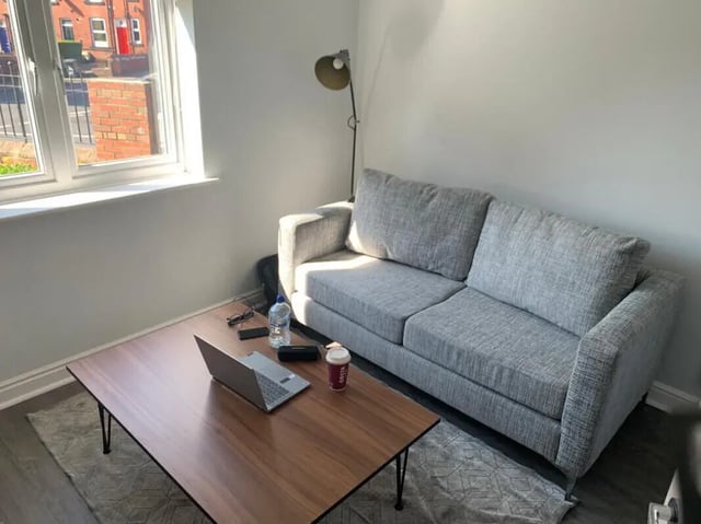 Sofa coffee table laptop bottle lamp living room at Welton Road in Leeds Student Accommodation