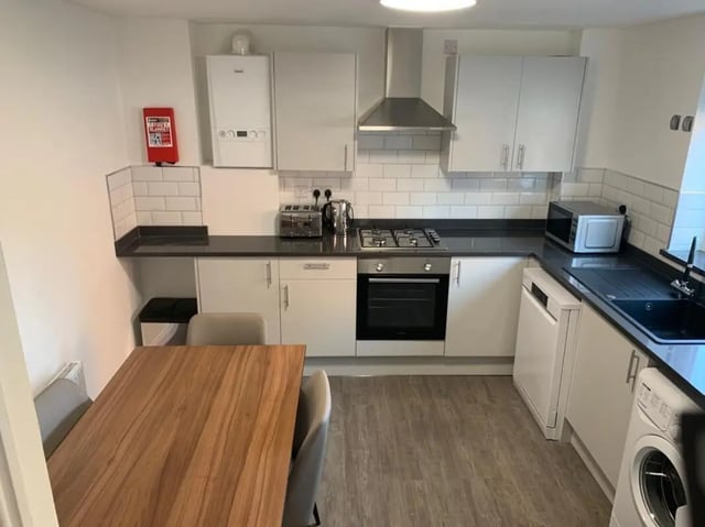 Table chairs oven microwave and appliances kitchen at Welton Road in Leeds Student Accommodation