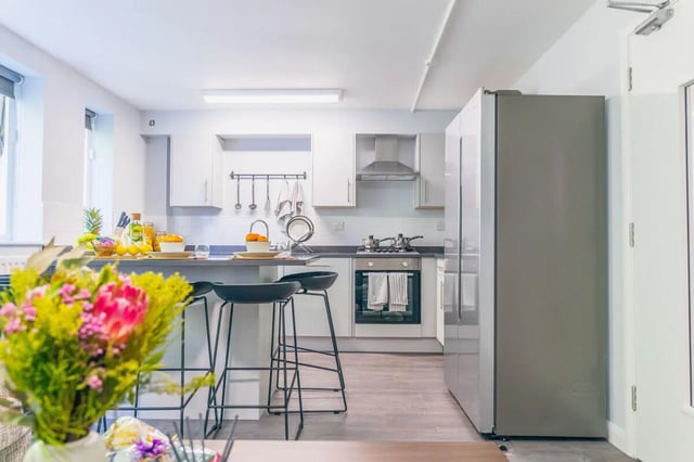 Kitchen with bar stools fridge and oven kitchen at Beech Gardens in Birmingham Student Accommodation