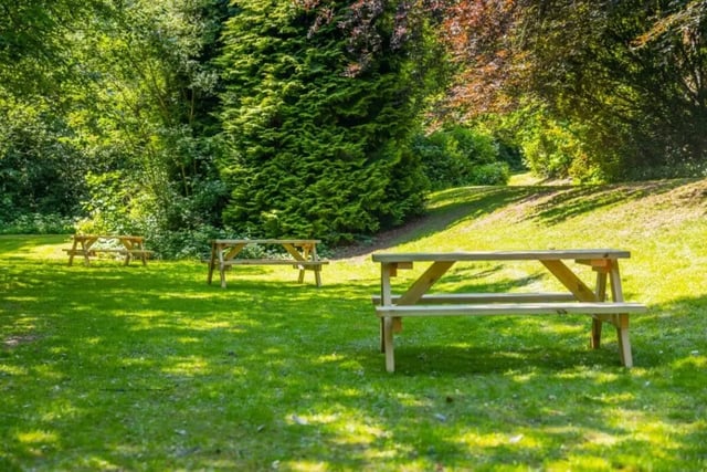Wooden picnic tables on grassy lawn exterior at Beech Gardens in Birmingham Student Accommodation