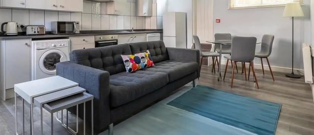 Sofa kitchen appliances dining table living room at The Coach House in Nottingham Student Accommodation