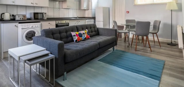 Sofa nesting tables washing machine kitchen area living room at The Coach House in Nottingham Student Accommodation