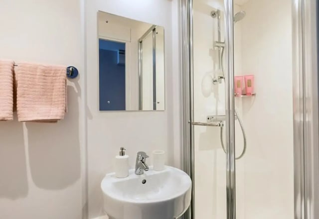 Sink mirror towels and shower stall bathroom at Queens Court in Reading Student Accommodation
