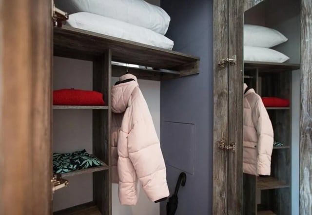 Open closet with pillows jackets and folded clothes closet at Queens Court in Reading Student Accommodation