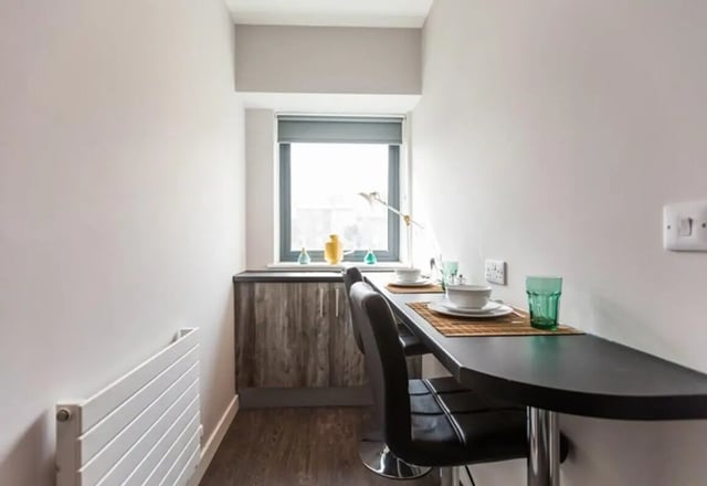 Table with chairs and dishes dining area at Queens Court in Reading Student Accommodation