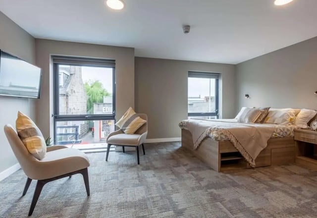 Bed chairs TV and window bedroom at The Combworks in Aberdeen Student Accommodation
