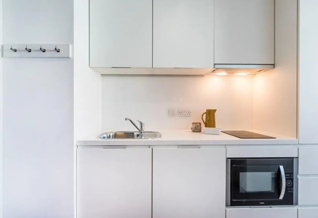 White cabinets sink microwave and jug kitchen at Vogue Studios in Brighton Student Accommodation