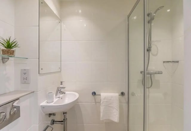 Sink mirror plant towel shower bathroom at Vogue Studios in Brighton Student Accommodation