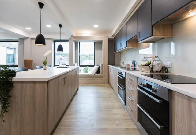 Island kitchen with modern appliances and seating nook kitchen at Caton Court in Lancaster Student Accommodation