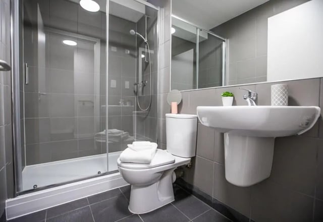 Shower toilet sink with towels and plant bathroom at Caton Court in Lancaster Student Accommodation