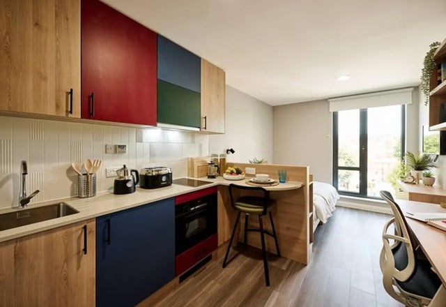 Compact kitchen area with sink and bed bedroom at The Spireworks in Oxford Student Accommodation