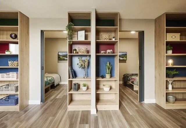 Bookshelves with decor separating two bedrooms bedroom at The Spireworks in Oxford Student Accommodation