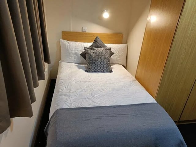 Bed pillows curtains wardrobe bedroom at Asha House in Loughborough Student Accommodation