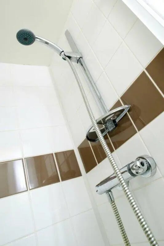 Showerhead and controls on tiled wall bathroom at Asha House in Loughborough Student Accommodation