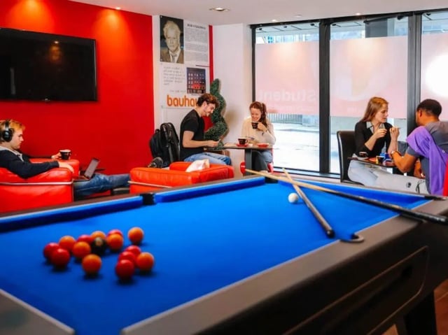 Pool table with people socializing communal area at Bauhaus Student Langstane Place in Aberdeen Student Accommodation