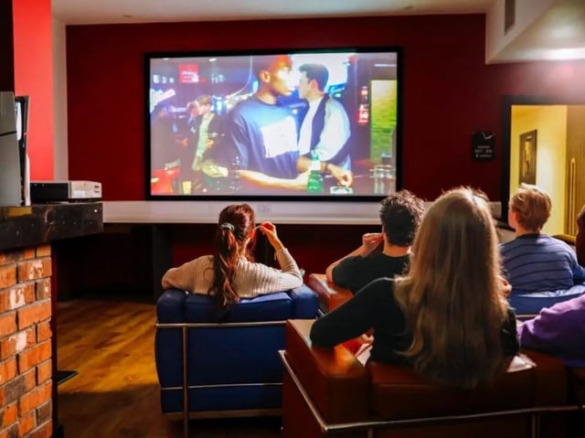 Students watching movie on a large screen living room at Bauhaus Student Langstane Place in Aberdeen Student Accommodation