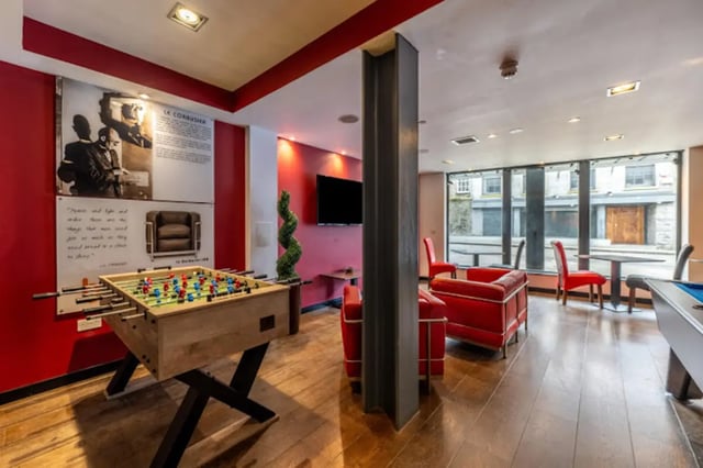 Foosball table red chairs lounge living room at Bauhaus Student Langstane Place in Aberdeen Student Accommodation