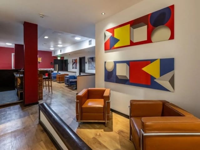 Brown leather armchairs with abstract art Living Room at Bauhaus Student Langstane Place in Aberdeen Student Accommodation