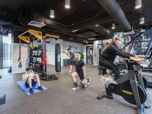 People exercising with weights boxing bag and bikes gym area at True Glasgow in Glasgow Student Accommodation