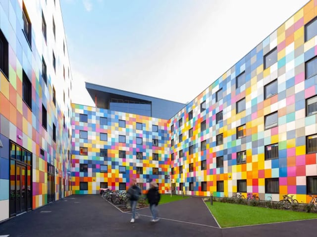 Colorful building facade with bicycles and people exterior at True Swansea in Swansea Student Accommodation