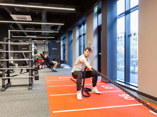 Men pulling rope on red mat gym playing area at True Swansea in Swansea Student Accommodation