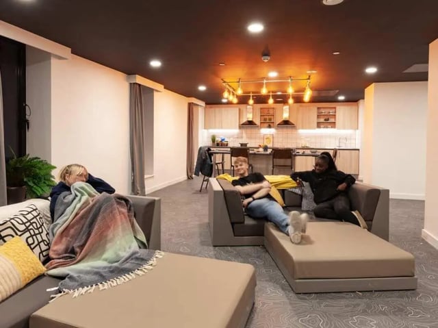 People relaxing on sofas kitchen area living room at True Swansea in Swansea Student Accommodation