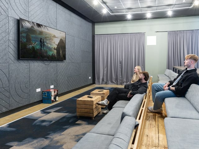 People watch TV in modern lounge living room at True Manchester-Salford in Salford Student Accommodation