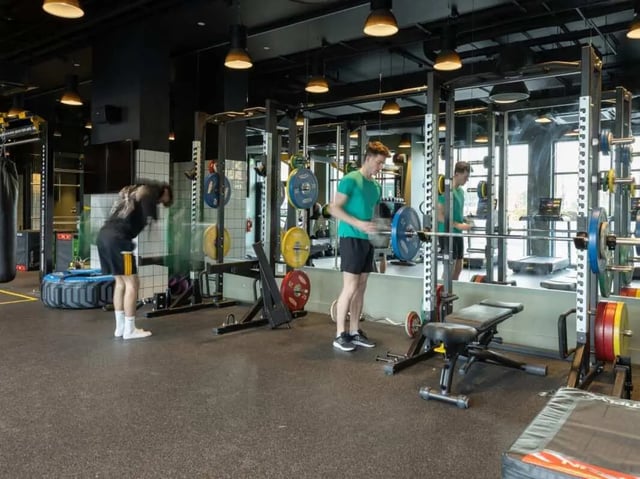 Gym equipment with people exercising gymnasium at True Manchester-Salford in Salford Student Accommodation