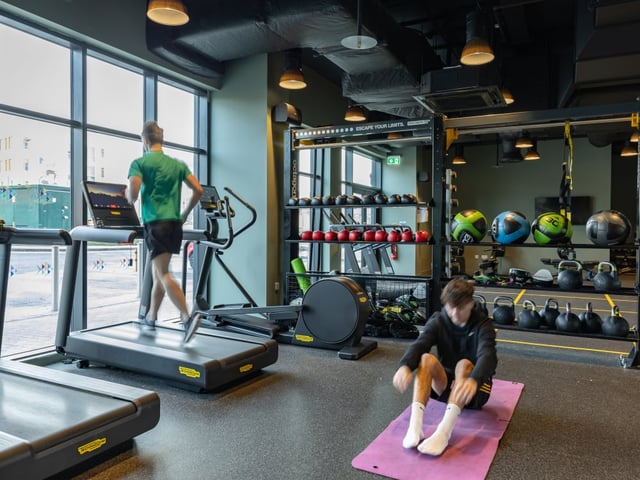 Treadmills weights and people exercising Gym at True Manchester-Salford in Salford Student Accommodation
