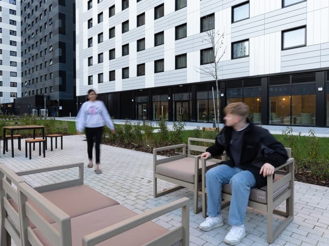 Outdoor seating area with modern buildings exterior at True Manchester-Salford in Salford Student Accommodation