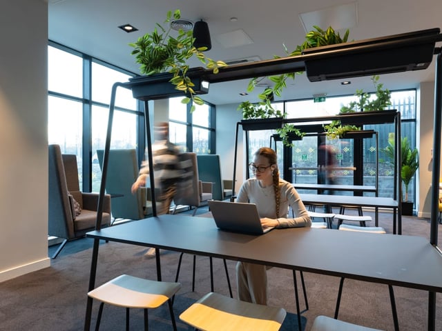Woman with laptop at table study area at True Manchester-Salford in Salford Student Accommodation