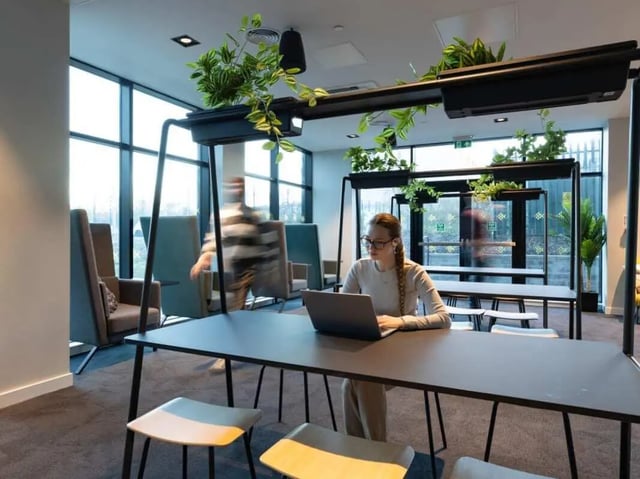 Woman with laptop at table study area at True Manchester-Salford in Salford Student Accommodation